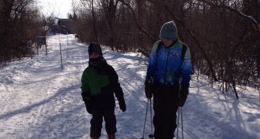 Photo d'un enfant et son moniteur en train de faire du ski de fond.