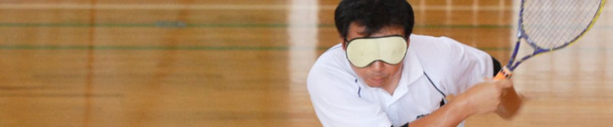Un joueur de tennis adapté frappe la balle, un bandeau sur les yeux. Crédit pgoto Ayako Matsui.