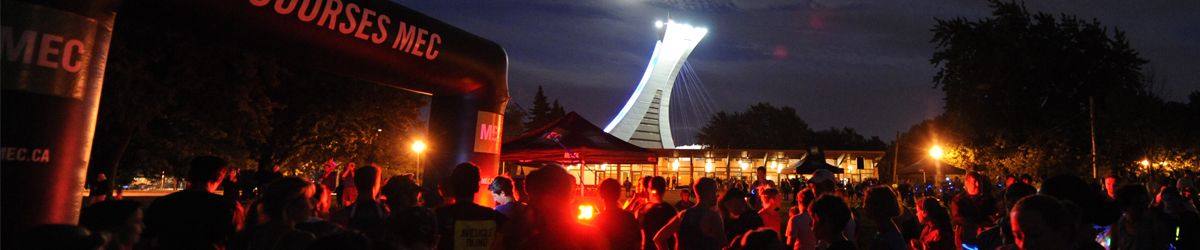 Photo des participants à la Course Lumière en attente du départ. La tour Olympique au fond illuminée.