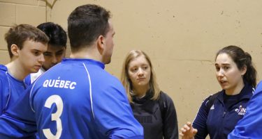 L'entraîneure en chef de l'équipe masculine de goalball du Québec, Nathalie Séguin, parle à Bruno Haché, Tristan Lépine-Lacroix, Raki Karim et Alexandra Piché lors d'un temps mort d'une partie de goalball.