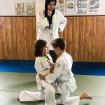 Du sport pour moi! Montréal - Judo. Sofia et Edgar qui se préparent à combattre et Louiza qui les observe.