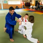 Du sport pour moi! Montréal - Judo. Stéphane qui explique le mouvement à Edgar et Sofia.