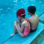 Programme Du sport pour moi! Printemps 2019 - Natation. Capitale-Nationale - Printemps 2019. Jeanne et Félix assient de dos, sur le bord de la piscine.