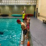 Programme Du sport pour moi! Printemps 2019 - Natation. Capitale-Nationale - Printemps 2019. Les enfants alignés debout sur le bord de la piscine pour faire de saut dans l'eau.