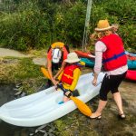 DSPM-Montréal-Automne 2019-Mayak. Clovis qui se prépare à aller sur l'eau à genoux sur le mayak, aidé par Danielle et sa maman.