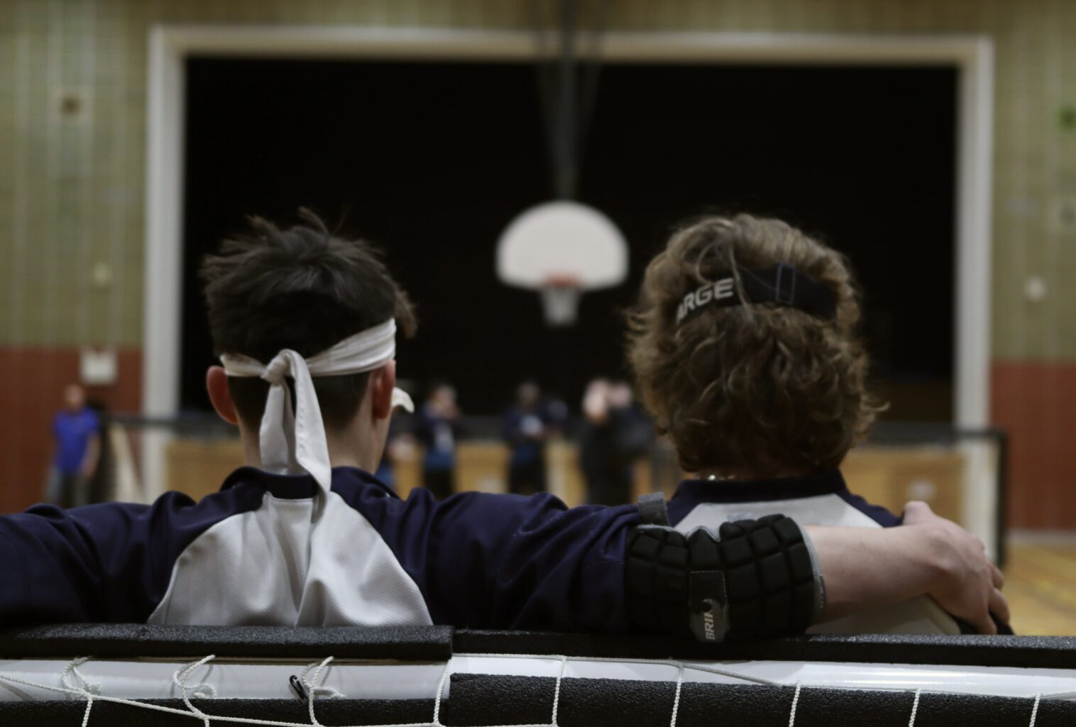 Deux joueurs de la Nouvelle-Écosse de dos, l’un ayant le bras autour des épaules de l’autre